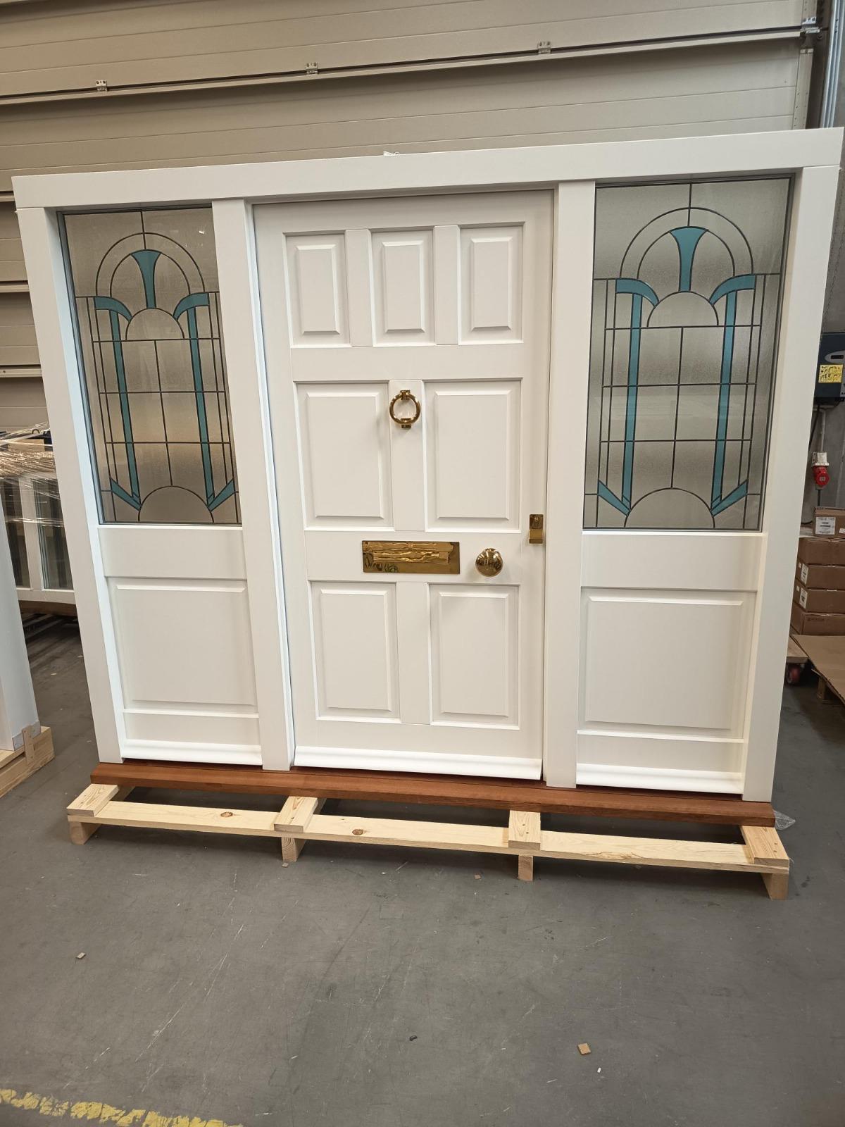 White timber front door with teal stained glass panels