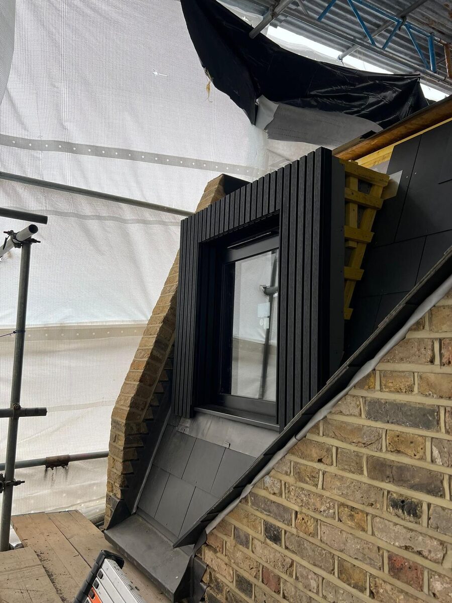 Black-framed timber casement window in a slate-clad dormer conversion