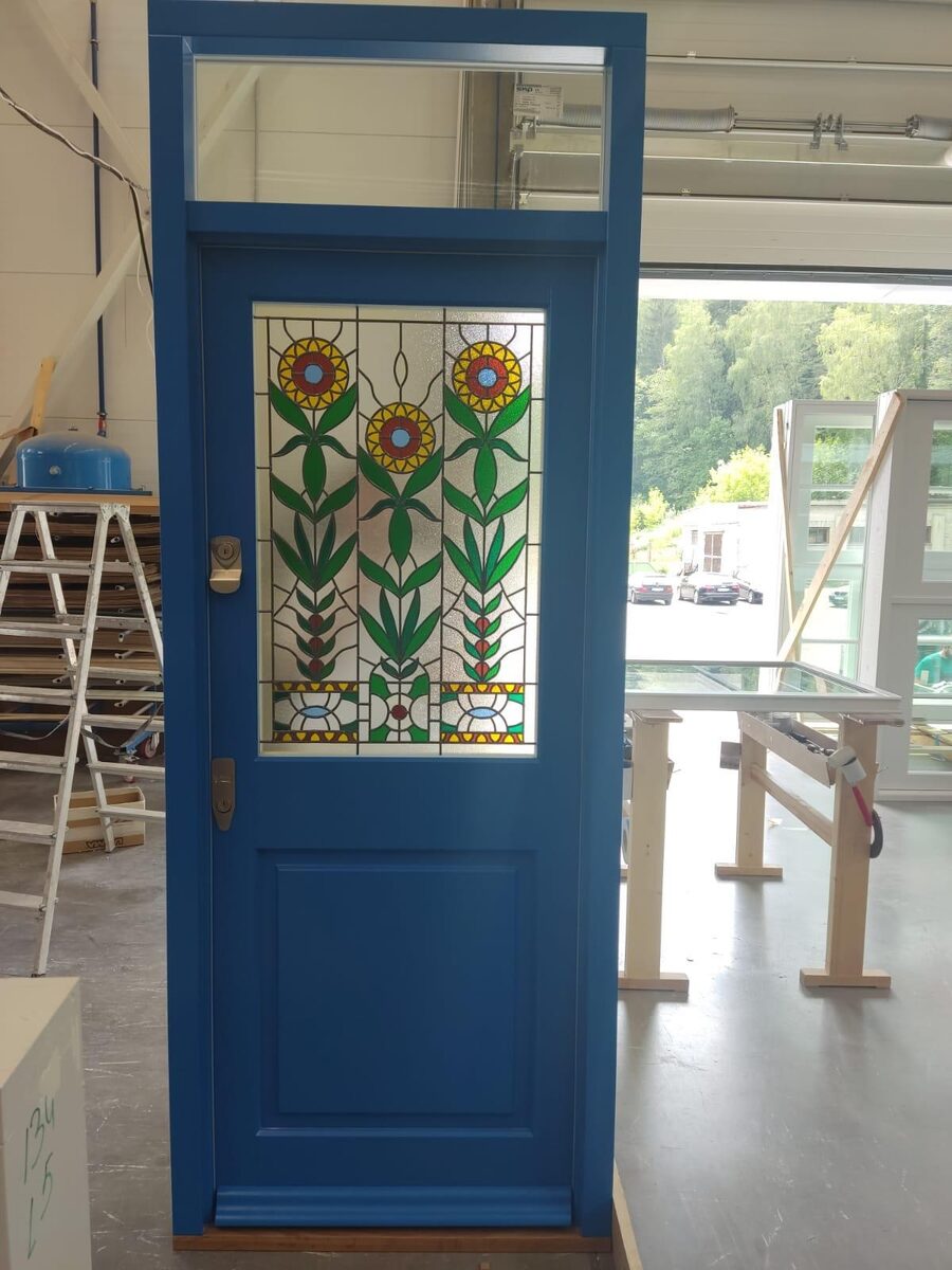 Blue Victorian timber front door with floral stained glass and glazed toplight