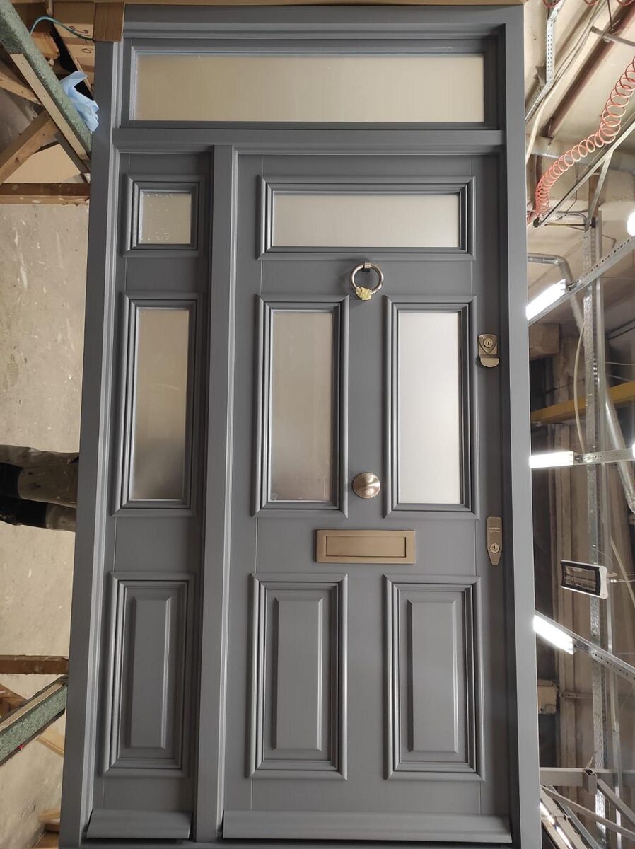 Grey Victorian timber front door with frosted sidelight, transom and brass furniture
