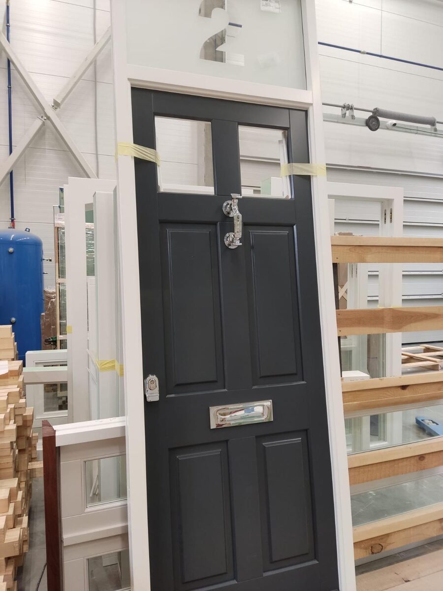Dark grey Georgian-style timber door with chrome knocker and letterplate