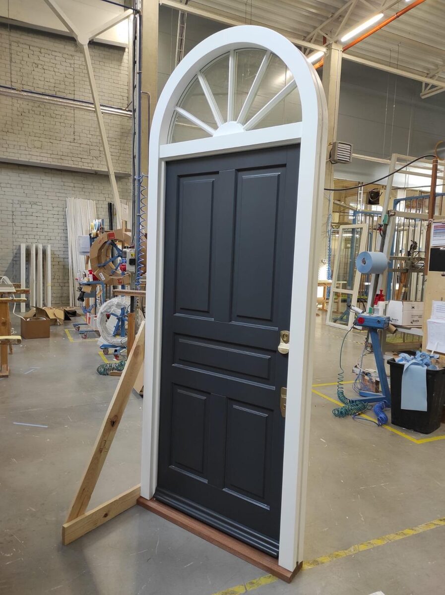 Navy panelled timber front door with arched sunburst fanlight in our joinery workshop