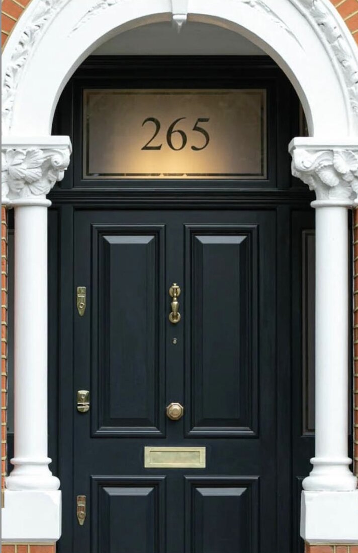 Navy timber front door with arched fanlight and stone portico