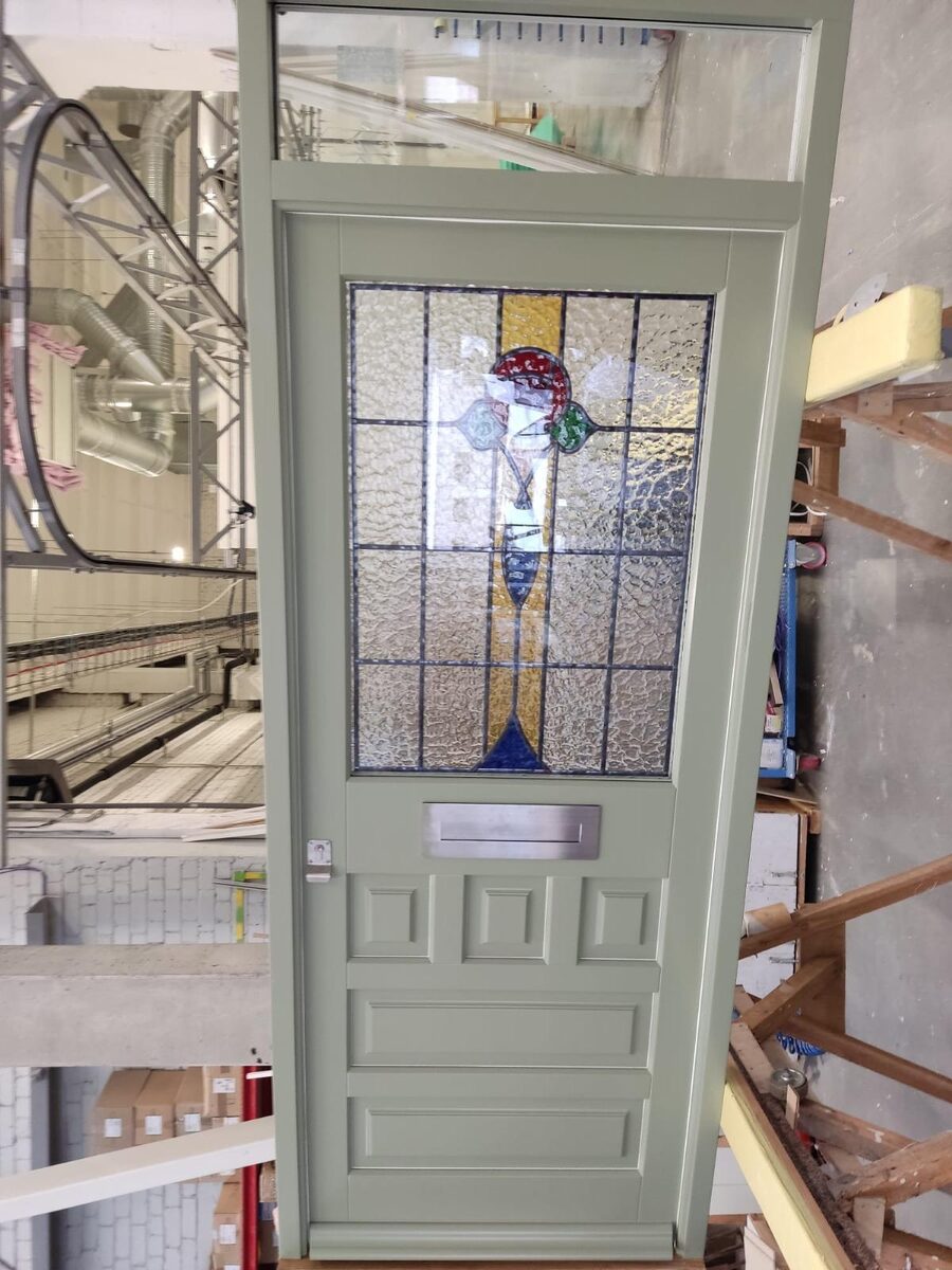 Sage green Victorian timber front door with original-style stained glass and toplight