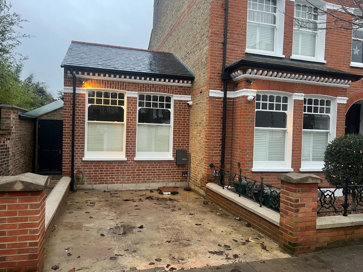 New timber sash windows in a red-brick side extension matching the original house