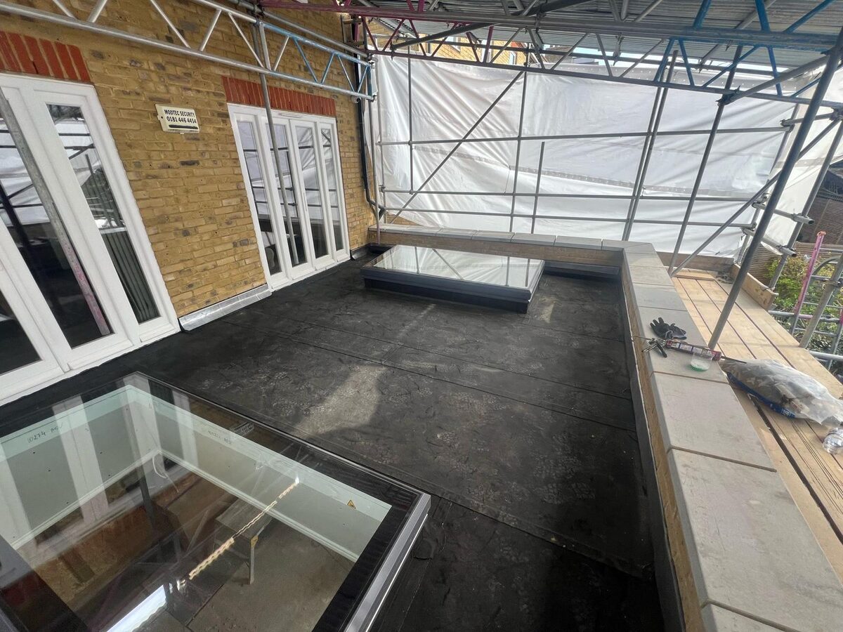 White timber French doors and windows opening onto a new roof terrace with rooflights