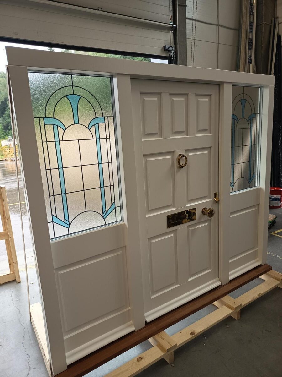 White timber front door set with Art Deco patterned glass sidelights