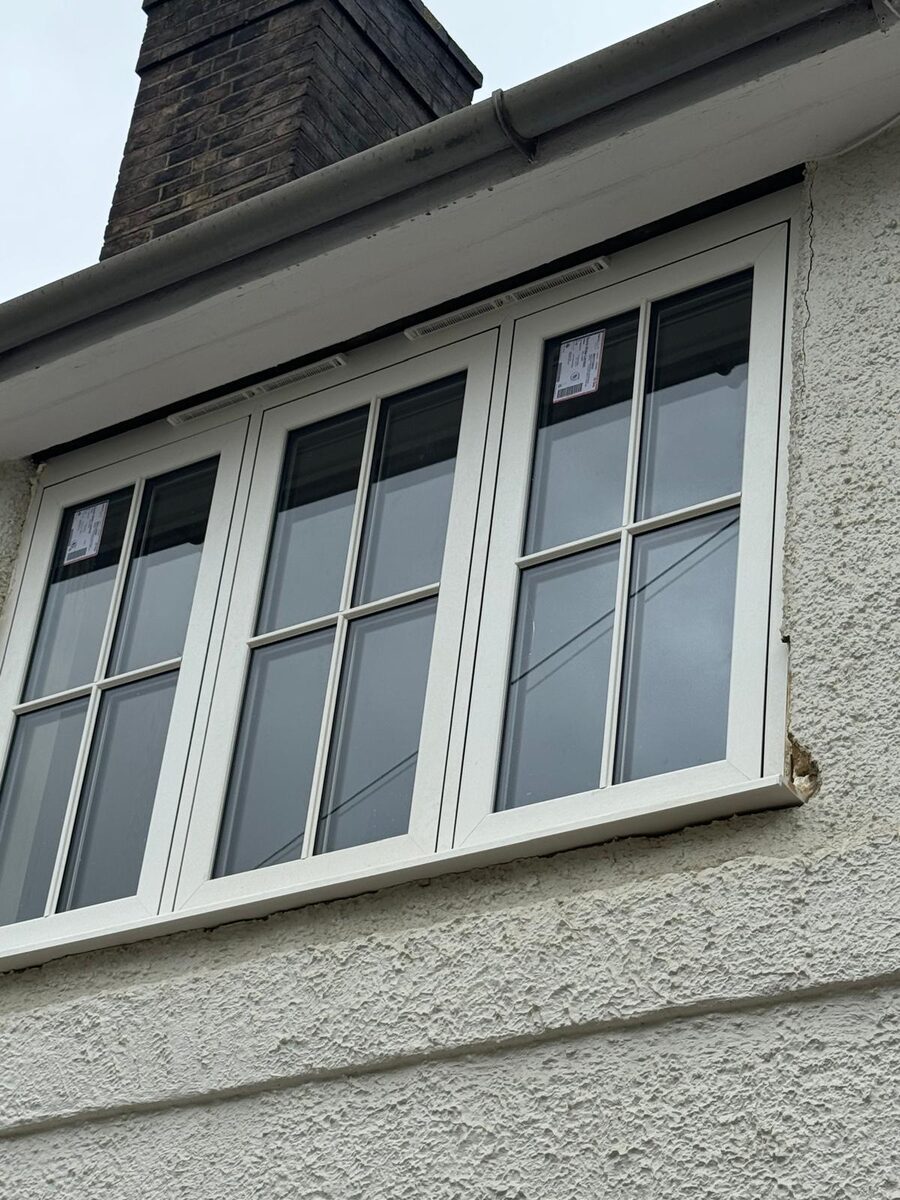 White timber casement windows with glazing bars on a rendered 1930s house