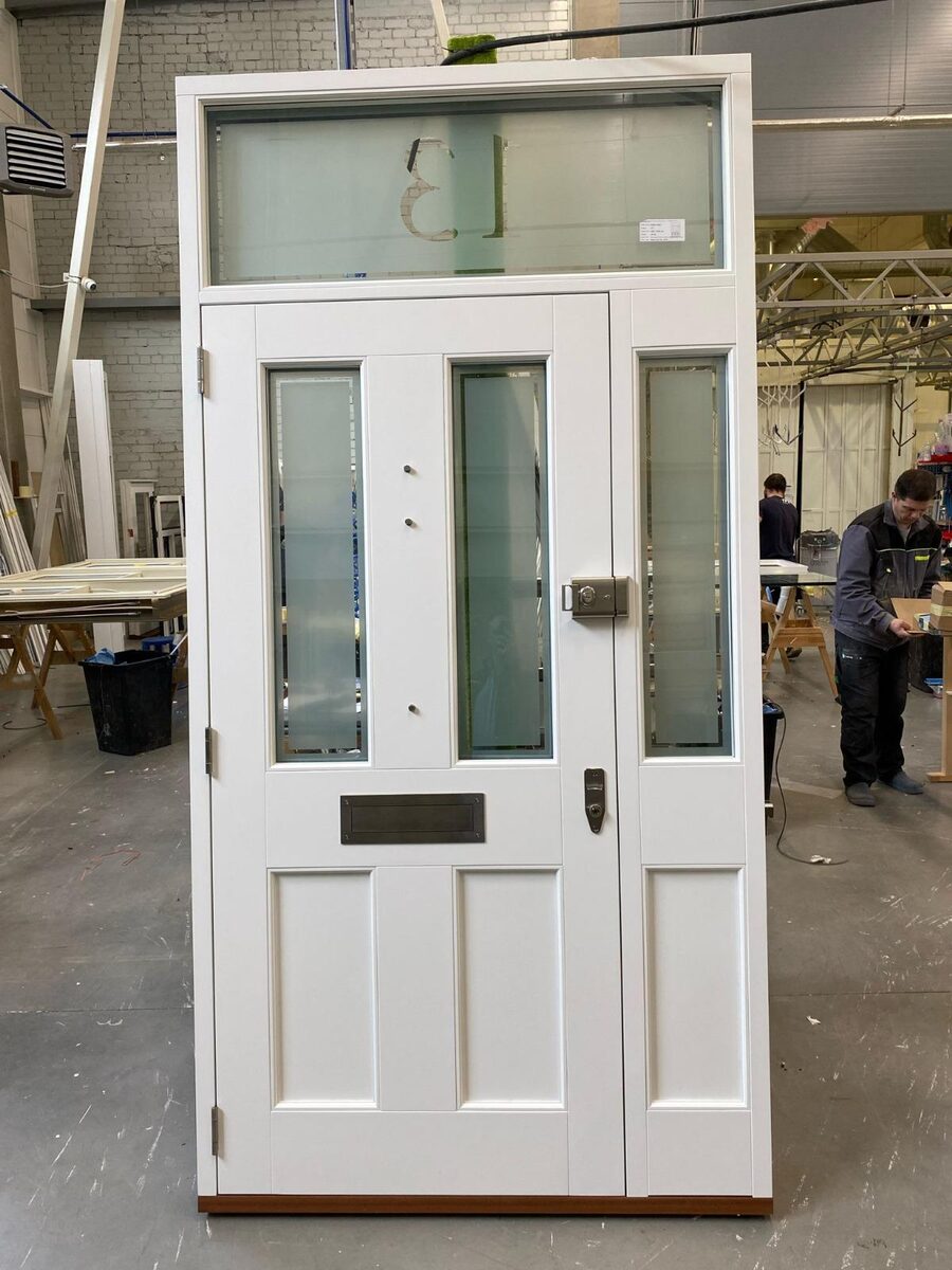 White Victorian timber door set with etched sidelights and numbered fanlight